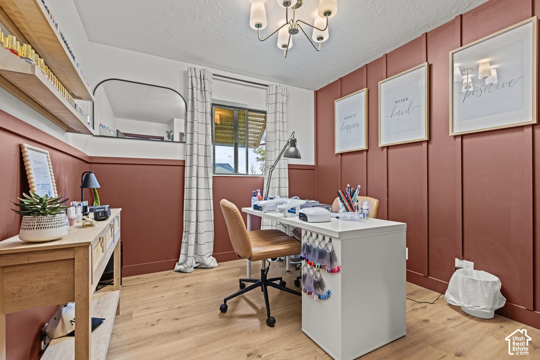 Dedicated home office featuring rich terracotta wall paneling, wood-finish flooring, and ample natural light from dual windows