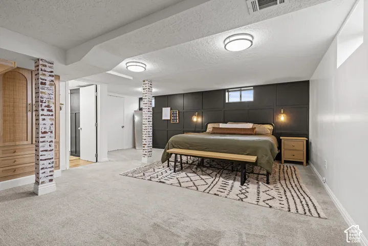 Plush carpeting, paneled accent wall, built-in cabinetry, and recessed lighting