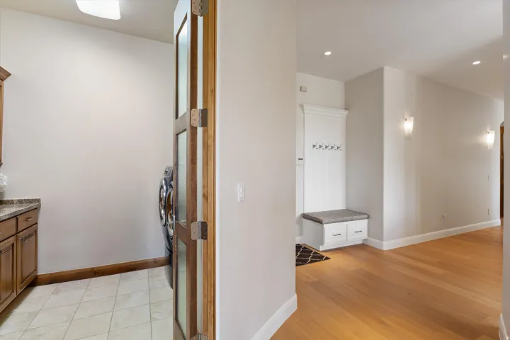 Hallway with wood-finish flooring, recessed lighting, and wall sconces