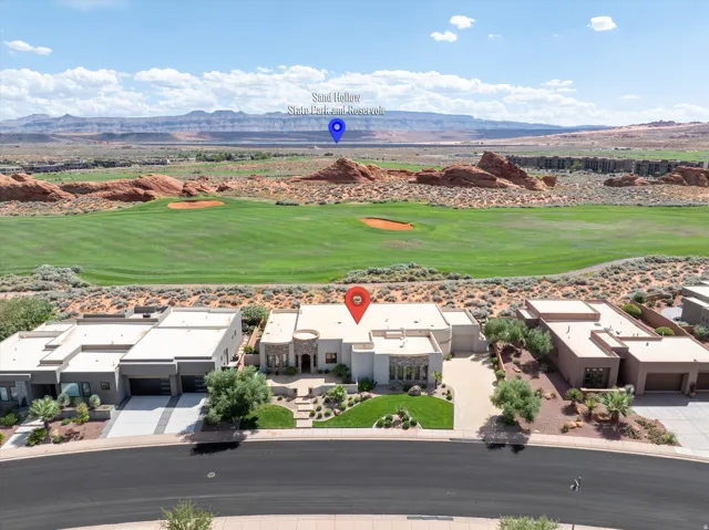 Modern desert-style residence with a flat roofline, an attached two-car garage, and a manicured front lawn
