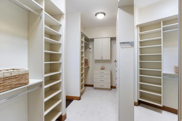 Expansive custom closet featuring extensive shelving, hanging rods, built-in cabinetry, and integrated drawer storage