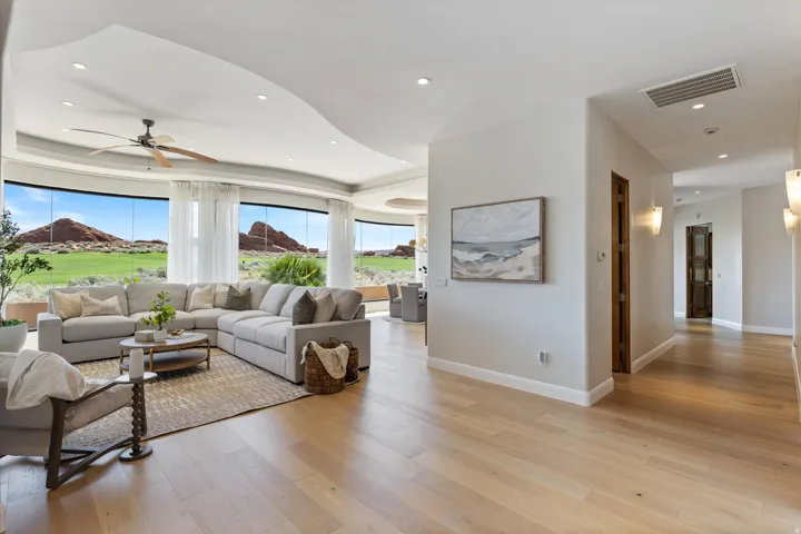 Expansive curved window wall, recessed lighting, wood-finish flooring, ceiling fan, and solid wood interior doors