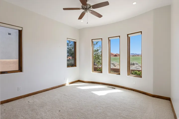 Neutral wall paint, carpeted flooring, wood-framed windows, ceiling fan, recessed lighting