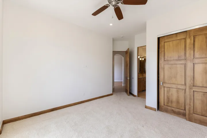 Carpeted flooring, wood-finish baseboards, wood-finish sliding closet doors, ceiling fan with light, recessed lighting