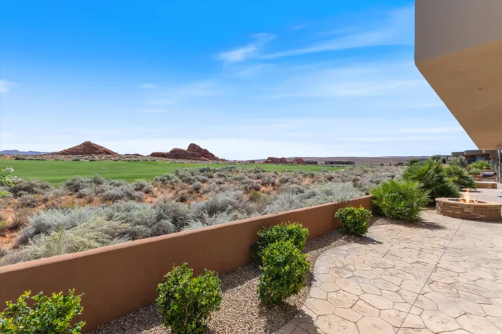 Expansive patio with stamped concrete, built-in stone fire pit, and professional landscaping