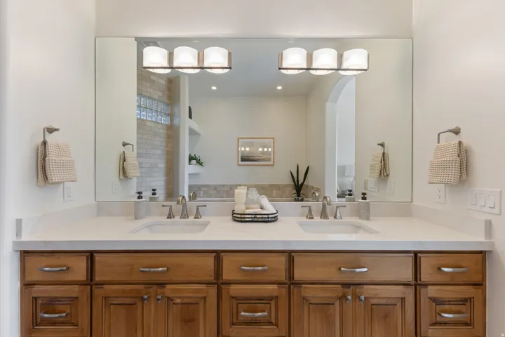 Double vanity with wood-finish cabinetry and brushed nickel hardware