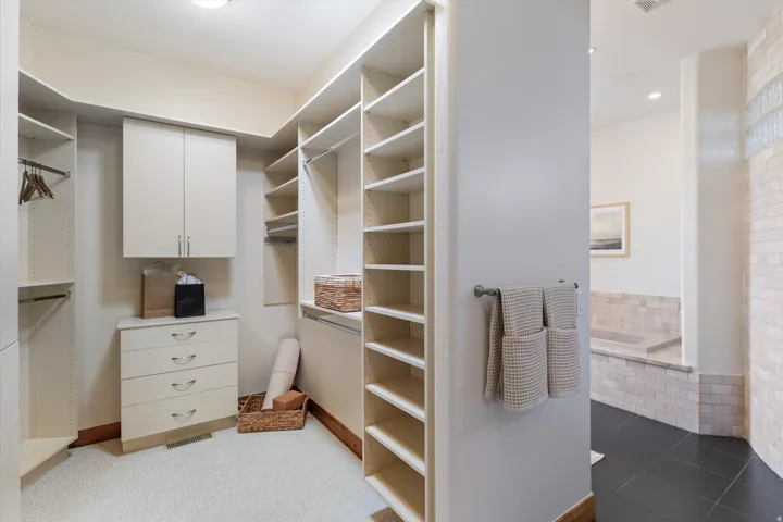 Walk-in closet with built-in cabinetry, integrated drawers, and extensive shelving