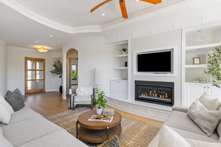 Living area featuring wood-finish flooring, a tray ceiling, and recessed lighting