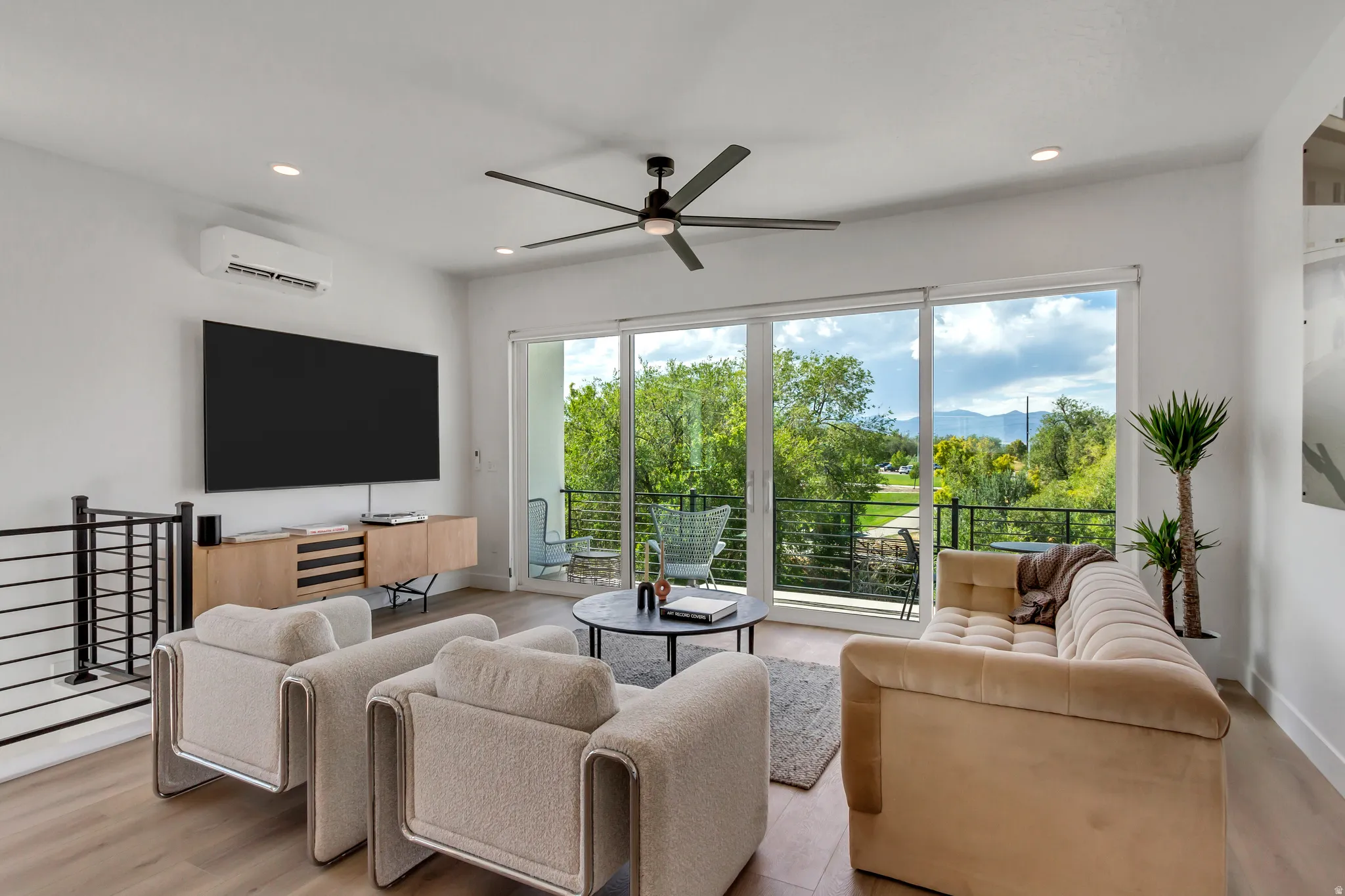 Recessed lighting, wood-finish flooring, and a ceiling fan with integrated lighting