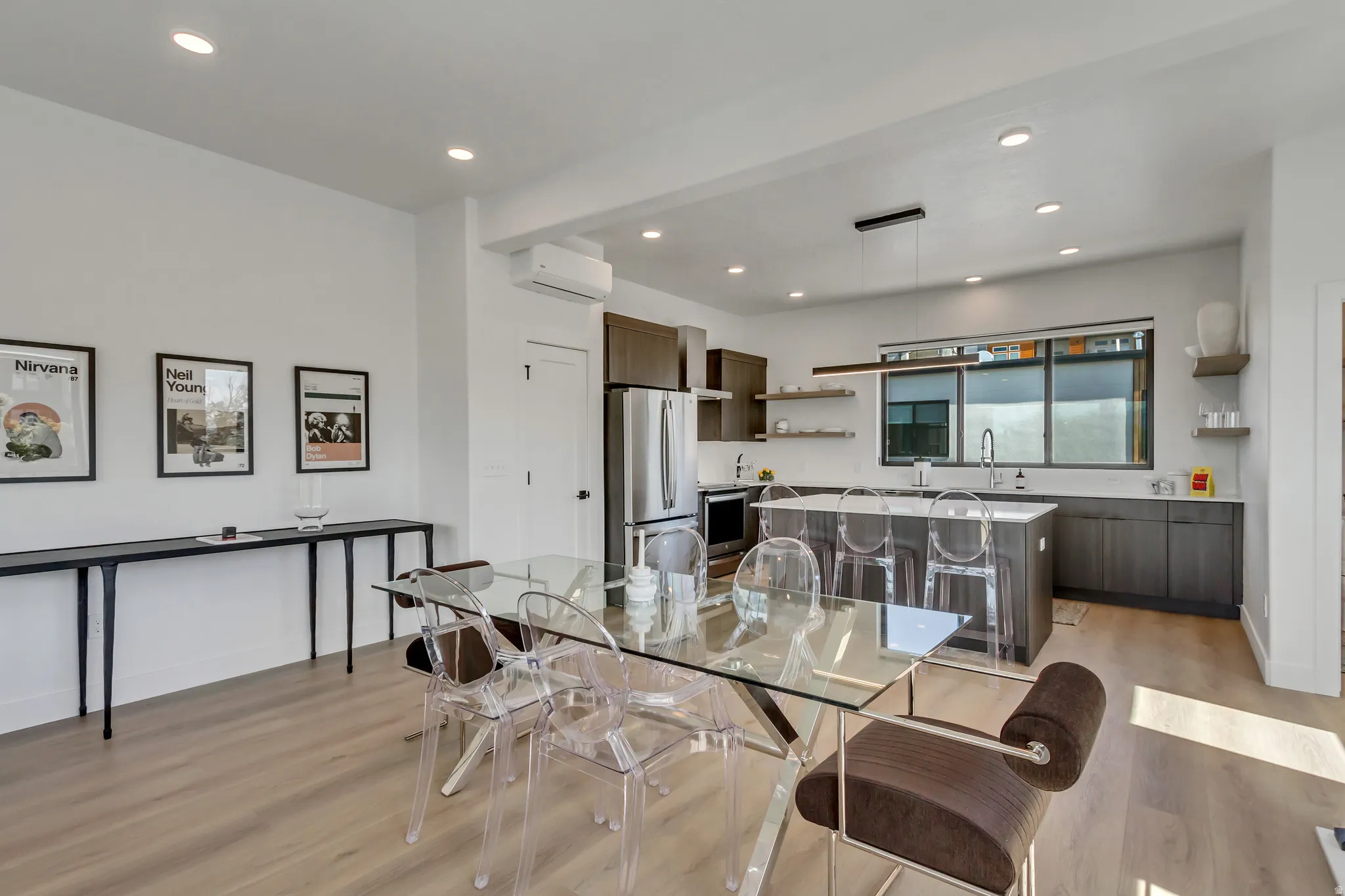 Open-concept layout with wood-finish flooring, recessed lighting, and a modern kitchen