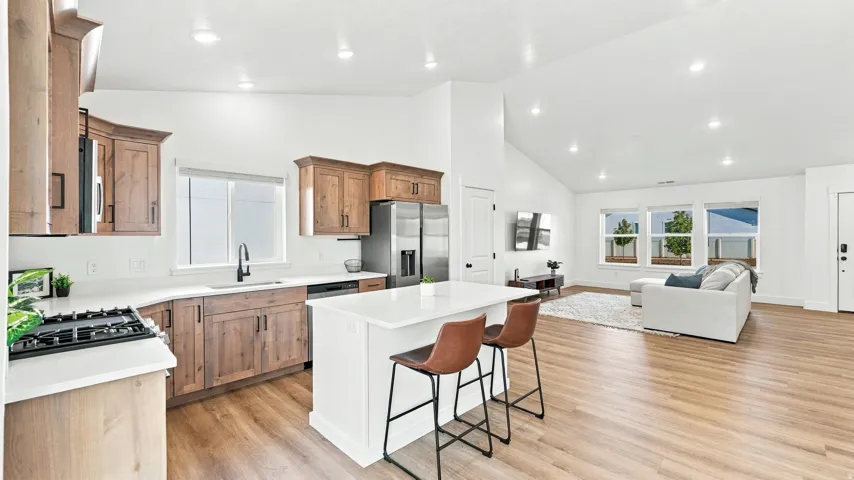 Kitchen featuring wood-finish cabinetry, stainless steel appliances, and a central island with countertop seating