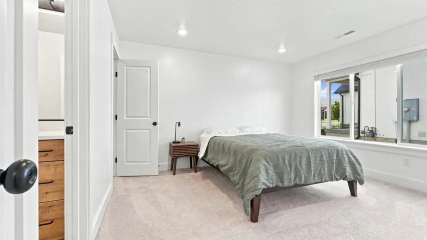 Plush carpeted flooring, recessed lighting, and a window with blinds