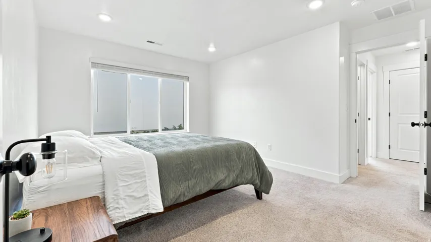 Recessed lighting, light-toned carpeting, white walls, and a window with blinds