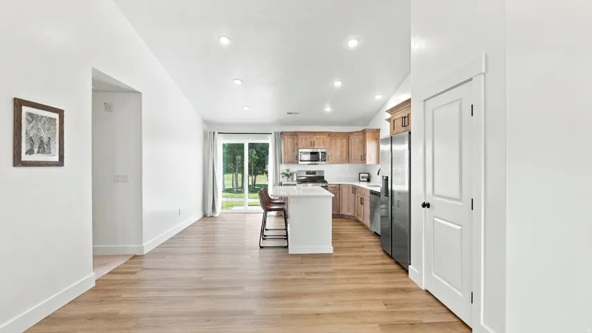 Kitchen featuring wood-finish cabinetry, stainless steel appliances, a center island with counter seating, and a white countertop