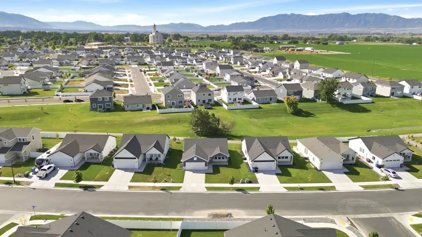 Expansive neighborhood featuring single-family residences with attached garages, paved driveways, and manicured lawns