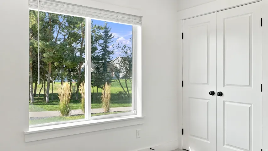 White interior walls, white window trim, white window blinds, bi-fold panel doors with matte black hardware