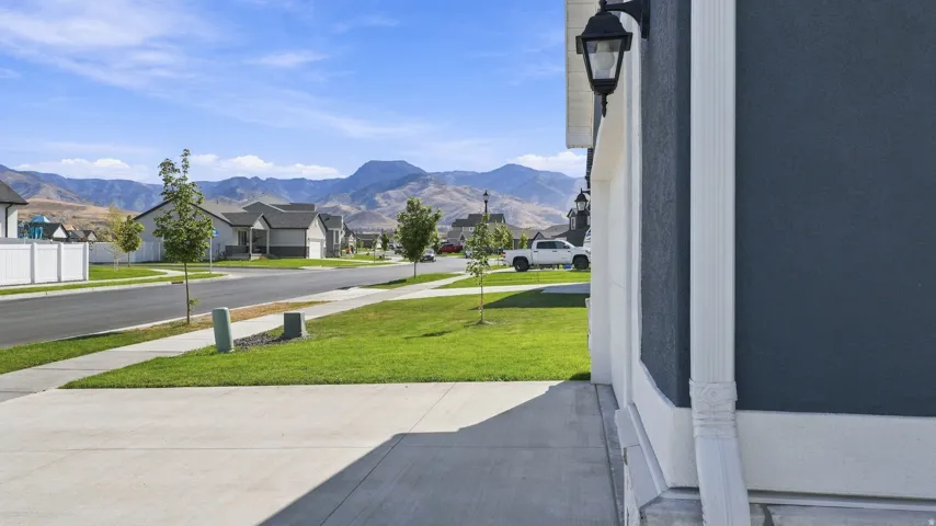 Exterior wall with dark stucco finish, white trim, and a wall-mounted lantern light fixture