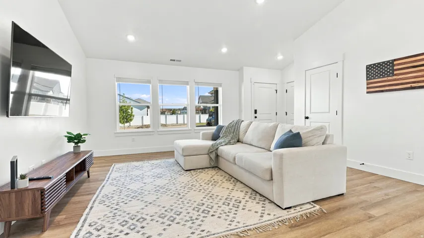 Recessed lighting, wood-finish flooring, white walls, and multiple windows