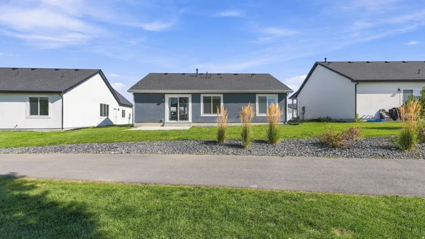 Rear exterior with a patio, sliding glass door, and dark gray siding