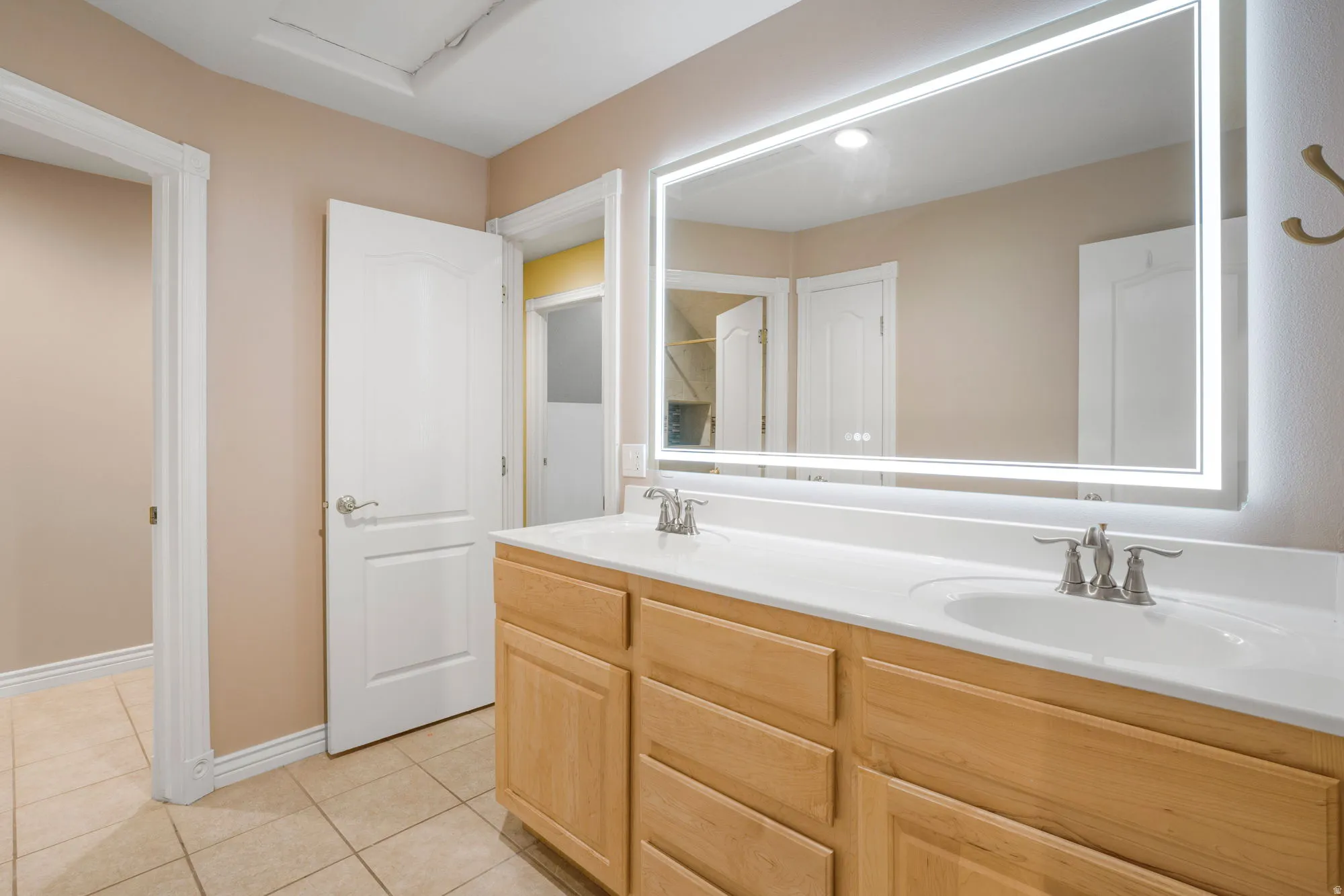 Double vanity with wood-finish cabinetry, integrated sinks, and brushed nickel faucets