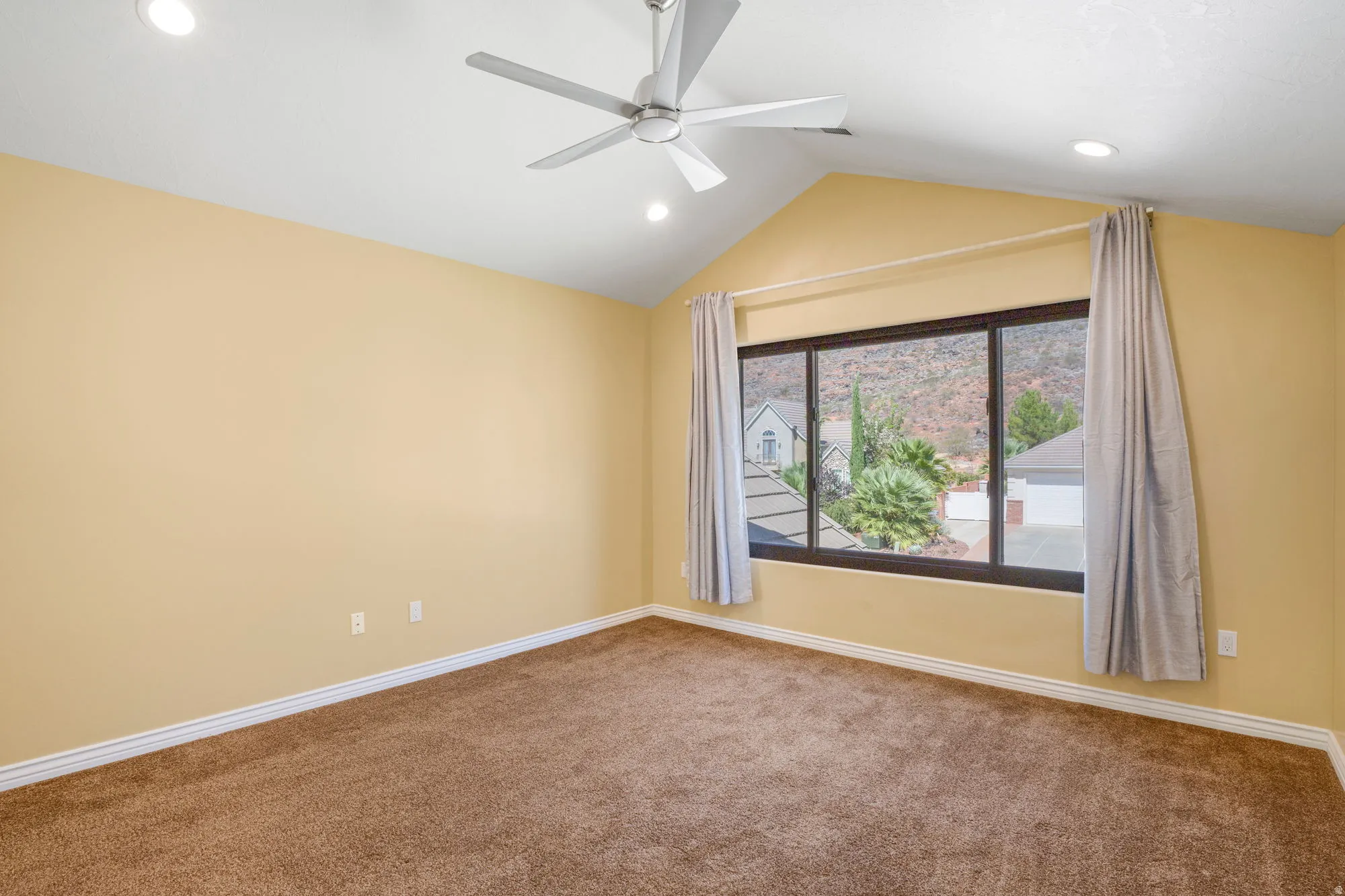 Vaulted ceiling with recessed lighting and a ceiling fan