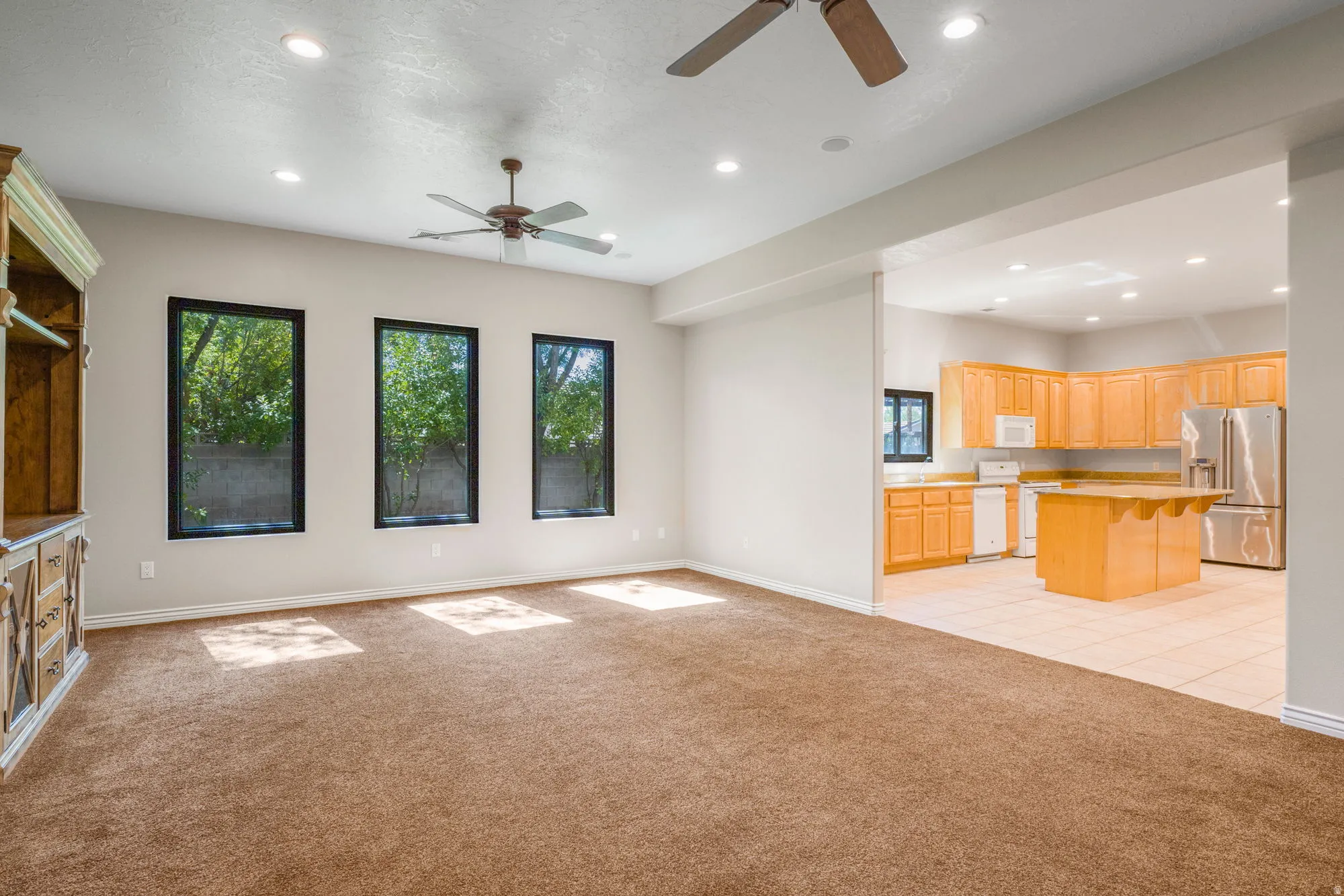 Recessed lighting, ceiling fans, and three large windows
