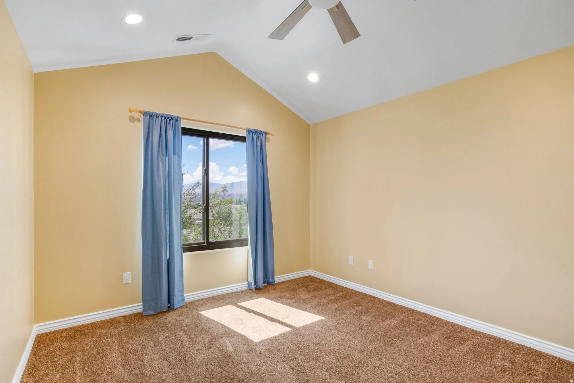 Vaulted ceiling with recessed lighting, ceiling fan, large window, and carpet flooring