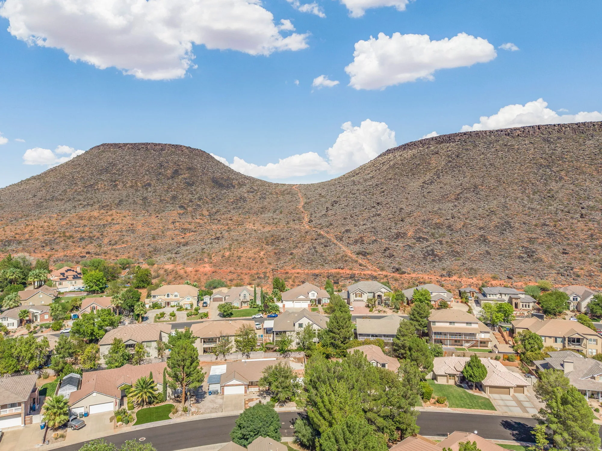 Residential area with varied architectural styles, mature landscaping, and prominent mountain backdrop