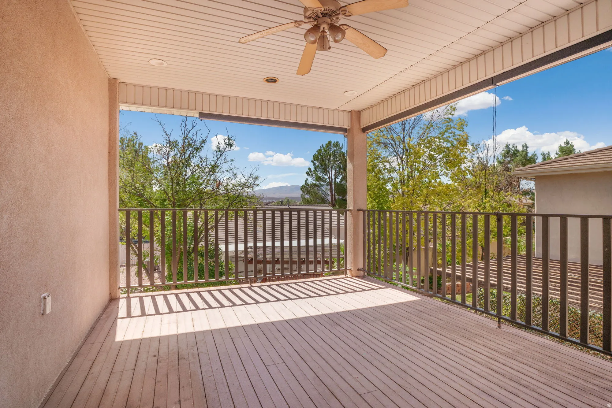 Expansive covered deck featuring wood-finish flooring, a ceiling fan, and recessed lighting