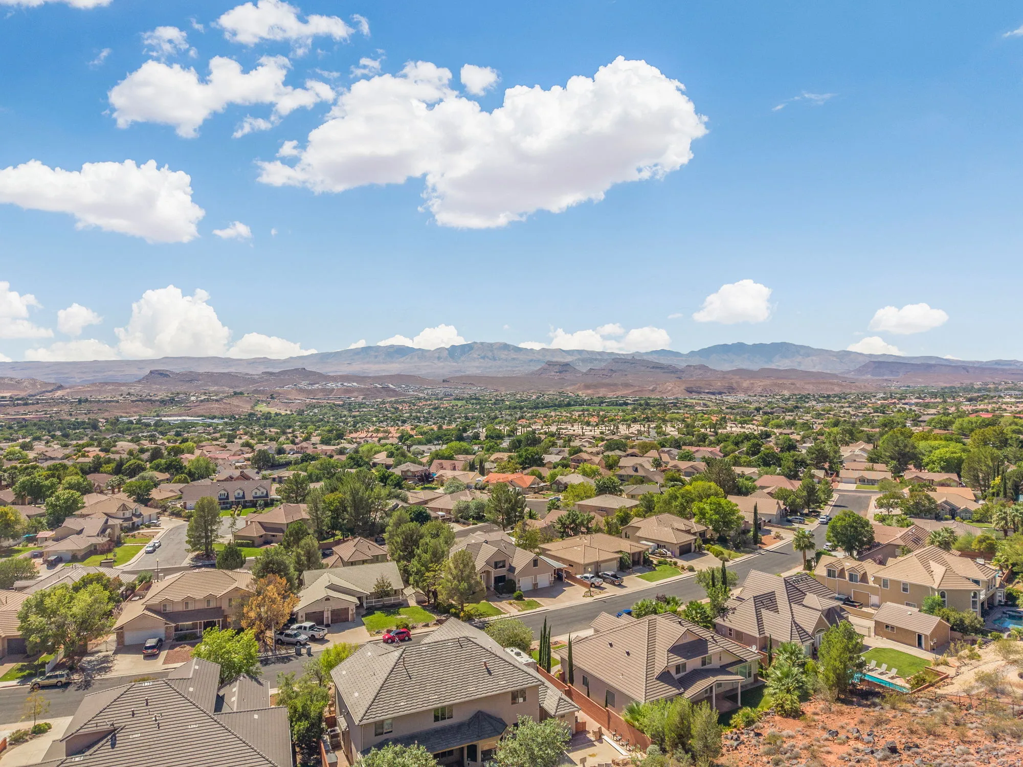 Expansive residential area with diverse home styles, mature landscaping, and mountain backdrop