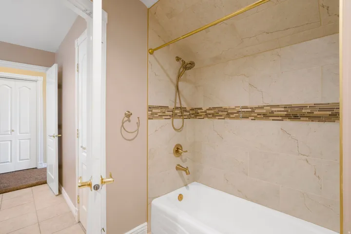 Tub and shower combination with a decorative tile surround and an accent mosaic tile band