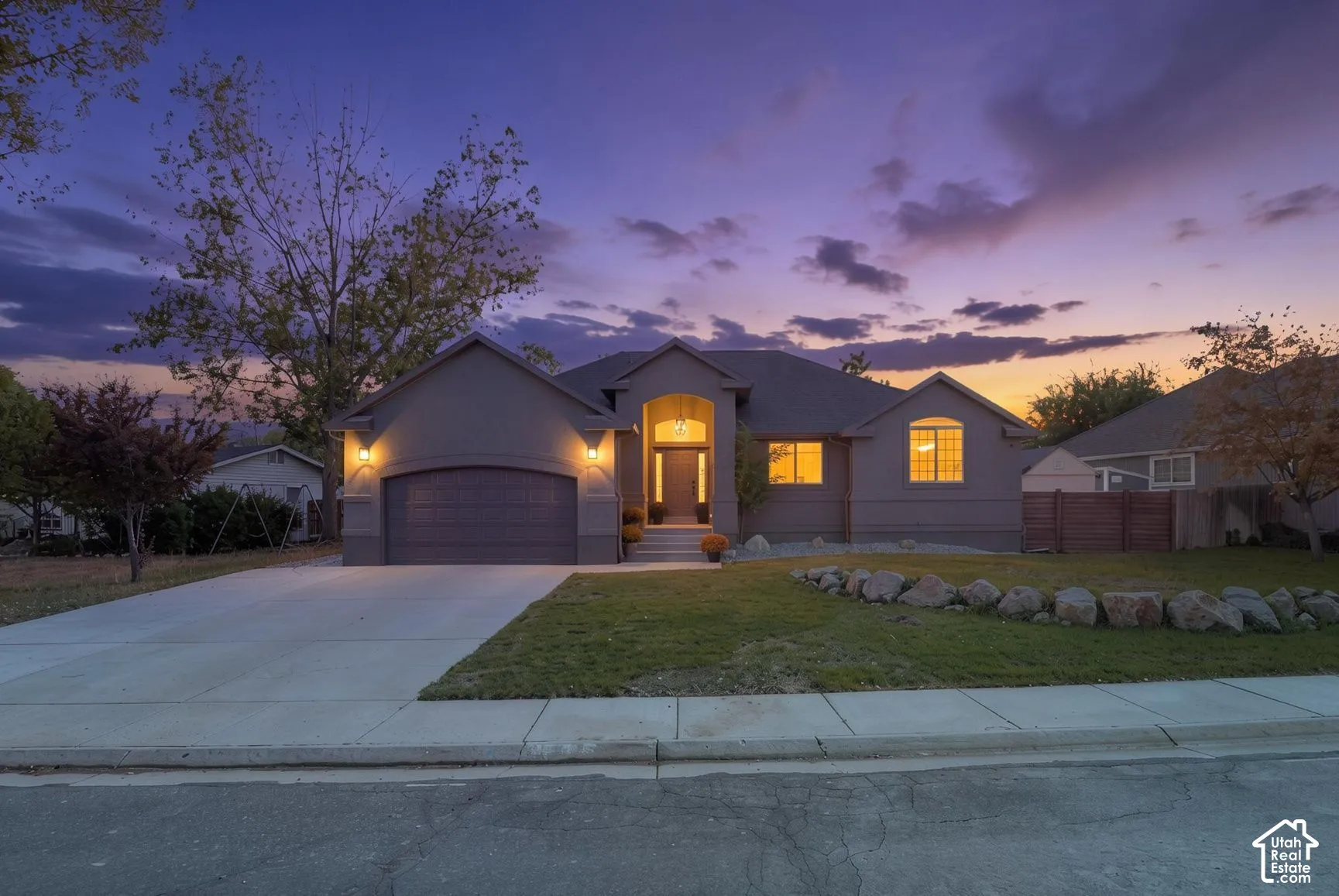 Stucco exterior with a prominent arched entry, an integrated garage, and a concrete driveway