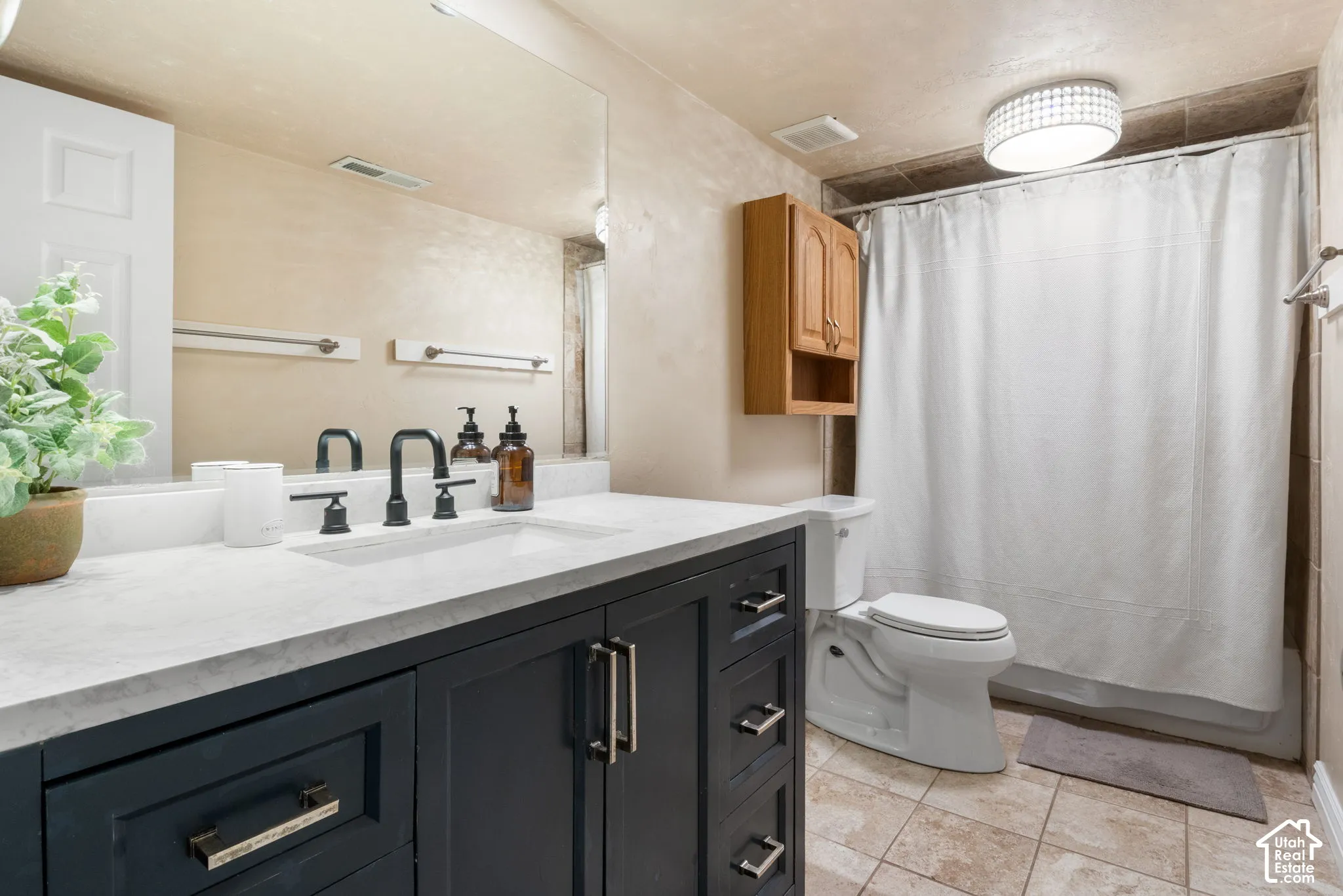 Black vanity with a white countertop, undermount sink, and matte black faucet