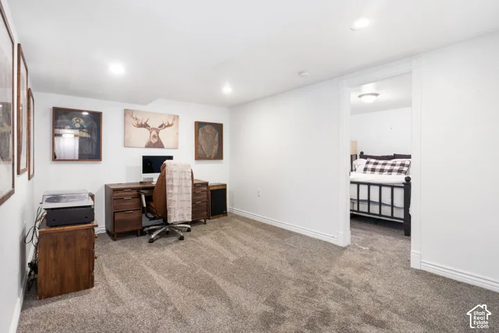 Recessed lighting, light gray carpet flooring, white painted walls, and an open doorway