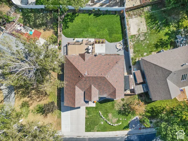 Expansive backyard featuring a manicured lawn, a built-in fire pit area, a large composite deck, and a paved patio