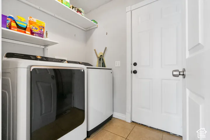 Laundry area featuring tiled flooring and upper shelving