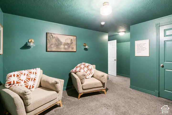 Carpeted flooring, wall-mounted sconces, and recessed lighting