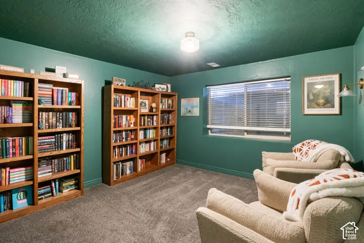 Carpeted flooring, window with blinds, and built-in wall sconce