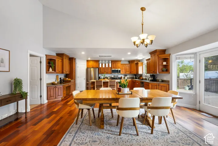 Vaulted ceiling, wood-finish flooring, recessed lighting, wood cabinetry, and a built-in kitchen island