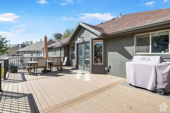 Expansive outdoor deck with a composite surface and dark railing, featuring a stucco exterior