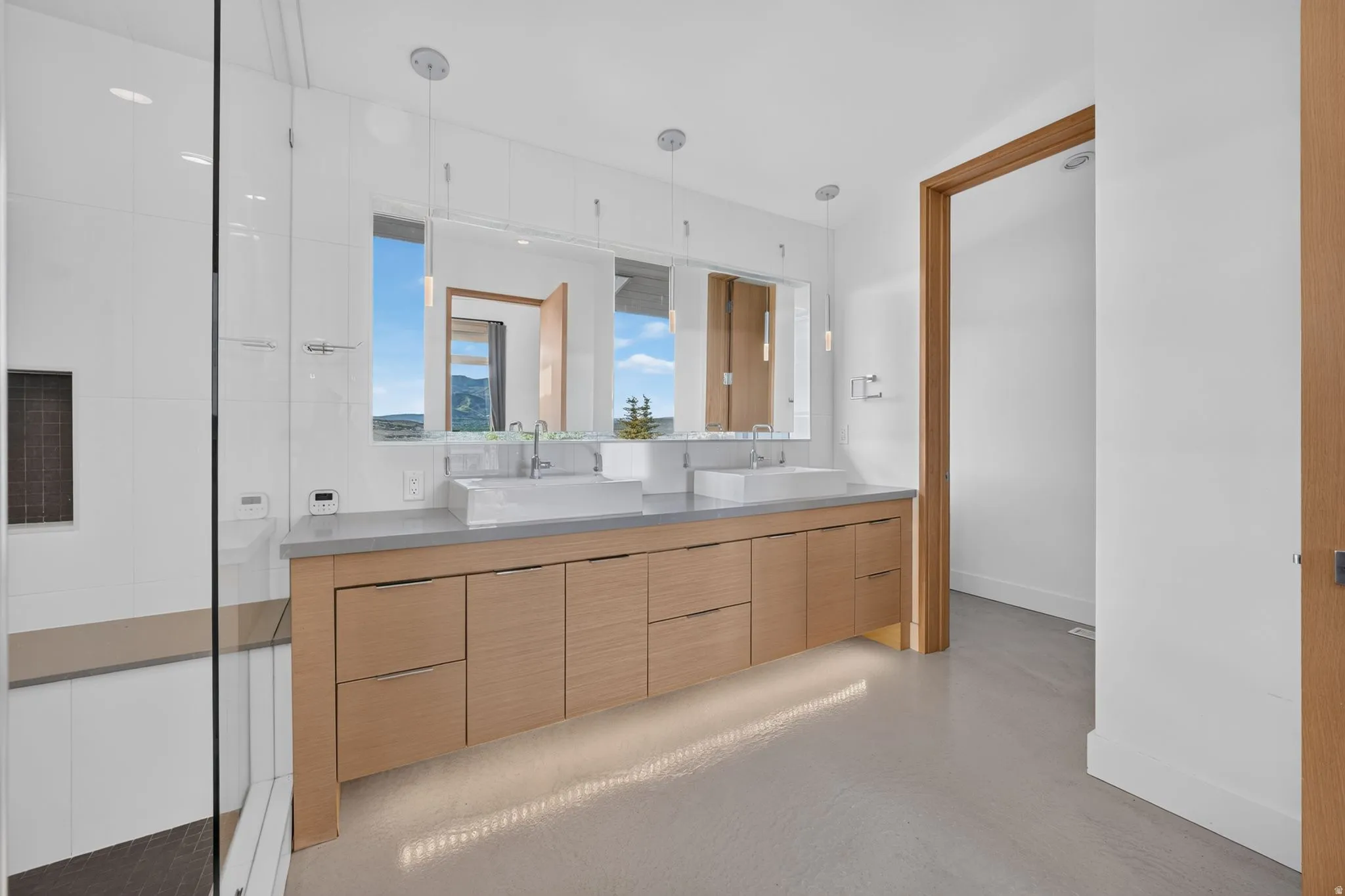 Dual vessel sinks on a wood-finish vanity with ample storage
