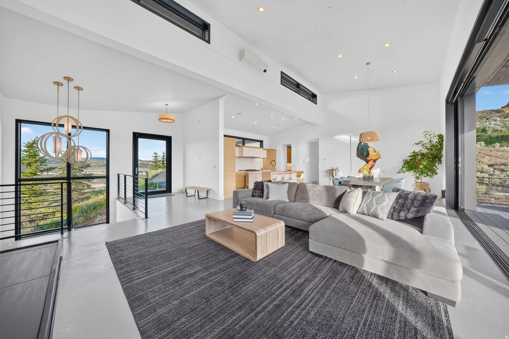 Expansive living area with high ceilings, recessed lighting, and large format flooring