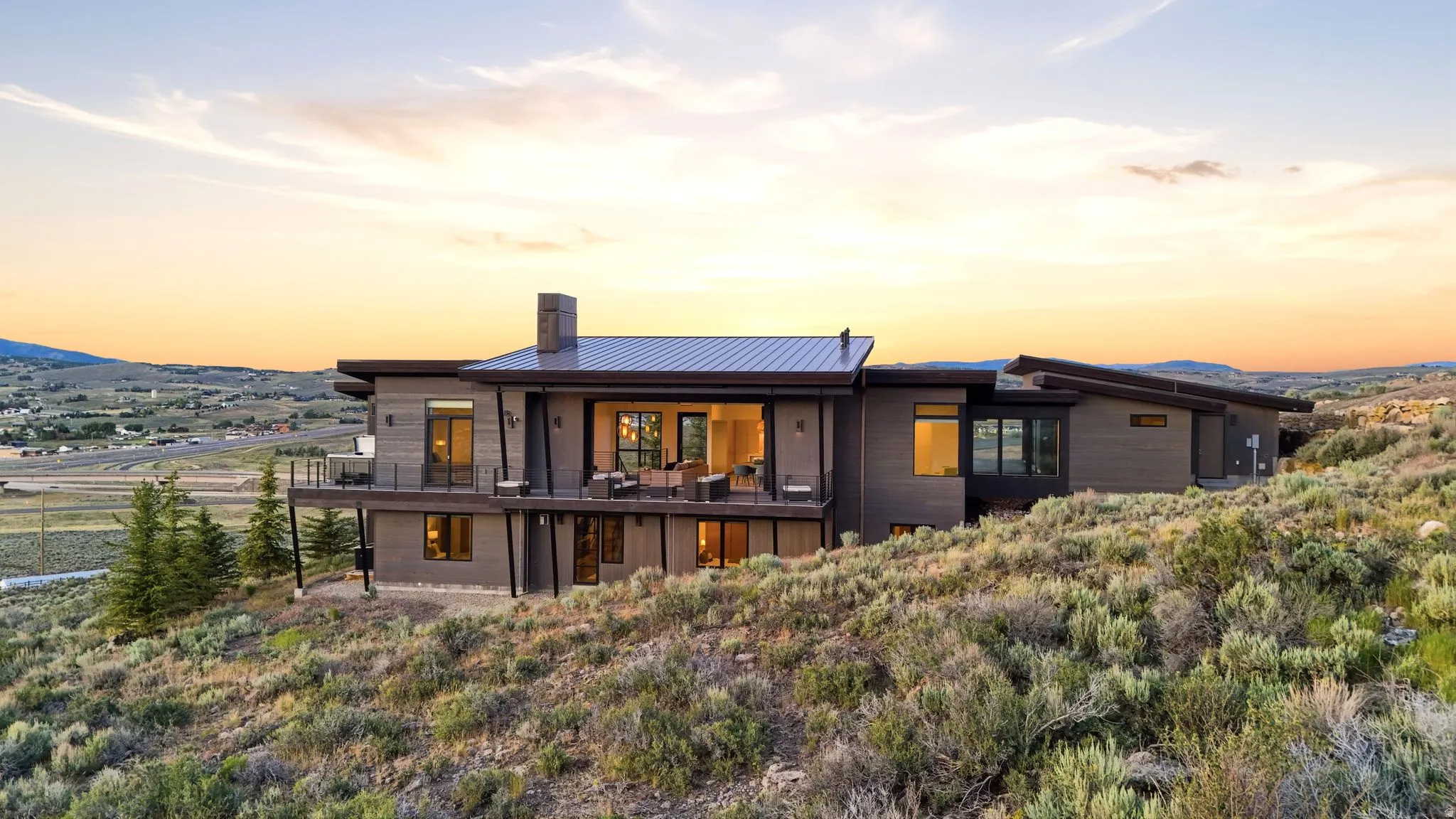 Contemporary exterior with multiple levels, expansive windows, and a metal roof