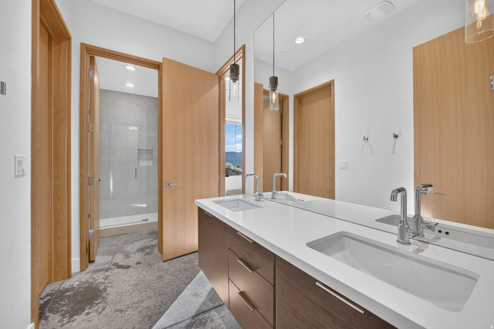 Dual vanity with integrated sinks, chrome fixtures, and dark wood-finish cabinetry