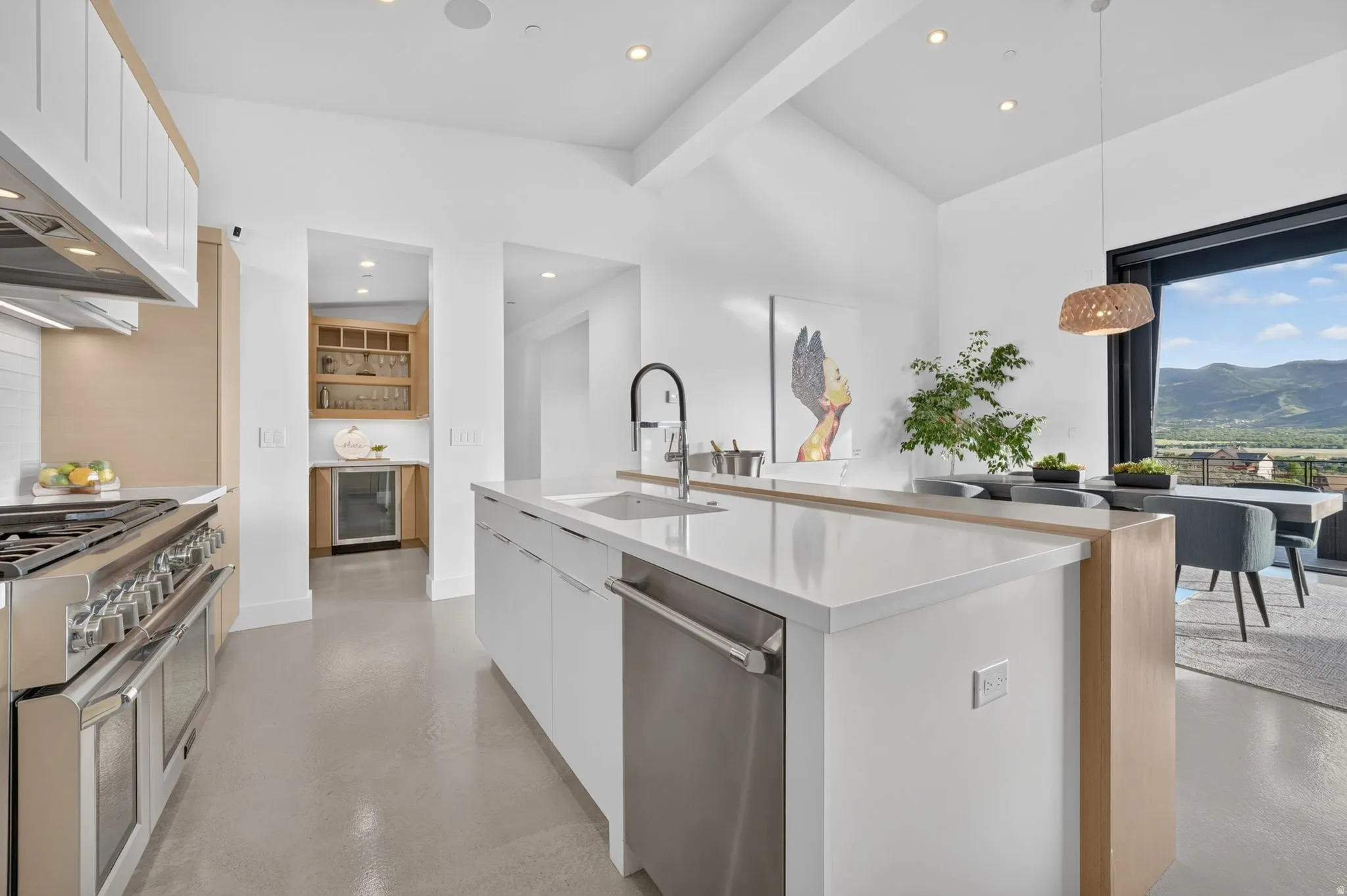 Spacious kitchen featuring an expansive island with a built-in sink and dishwasher, a professional-grade range, and recessed lighting