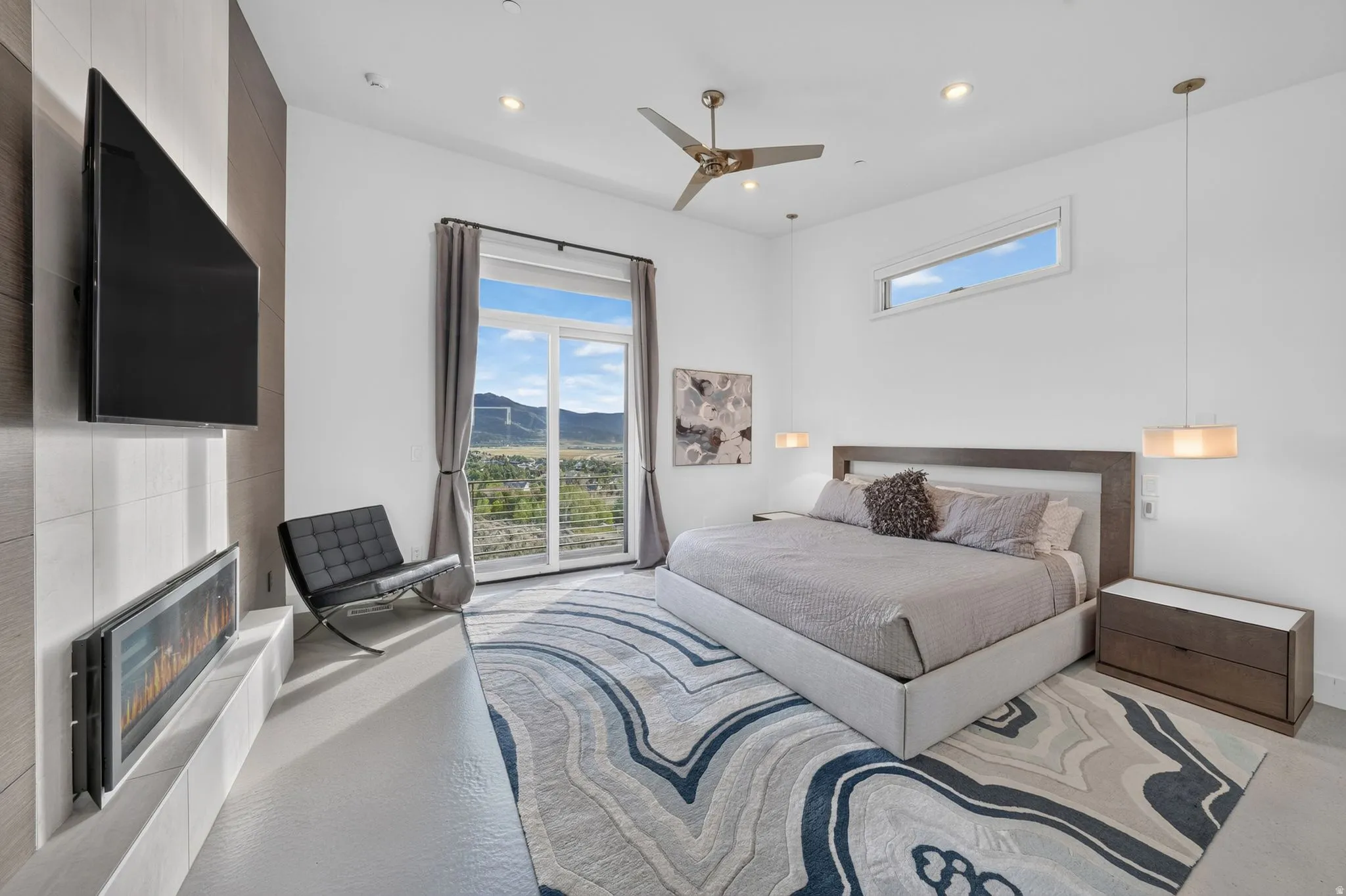 Sliding glass door, wall-mounted electric fireplace, wood-finish accent wall, modern ceiling fan, and transom window