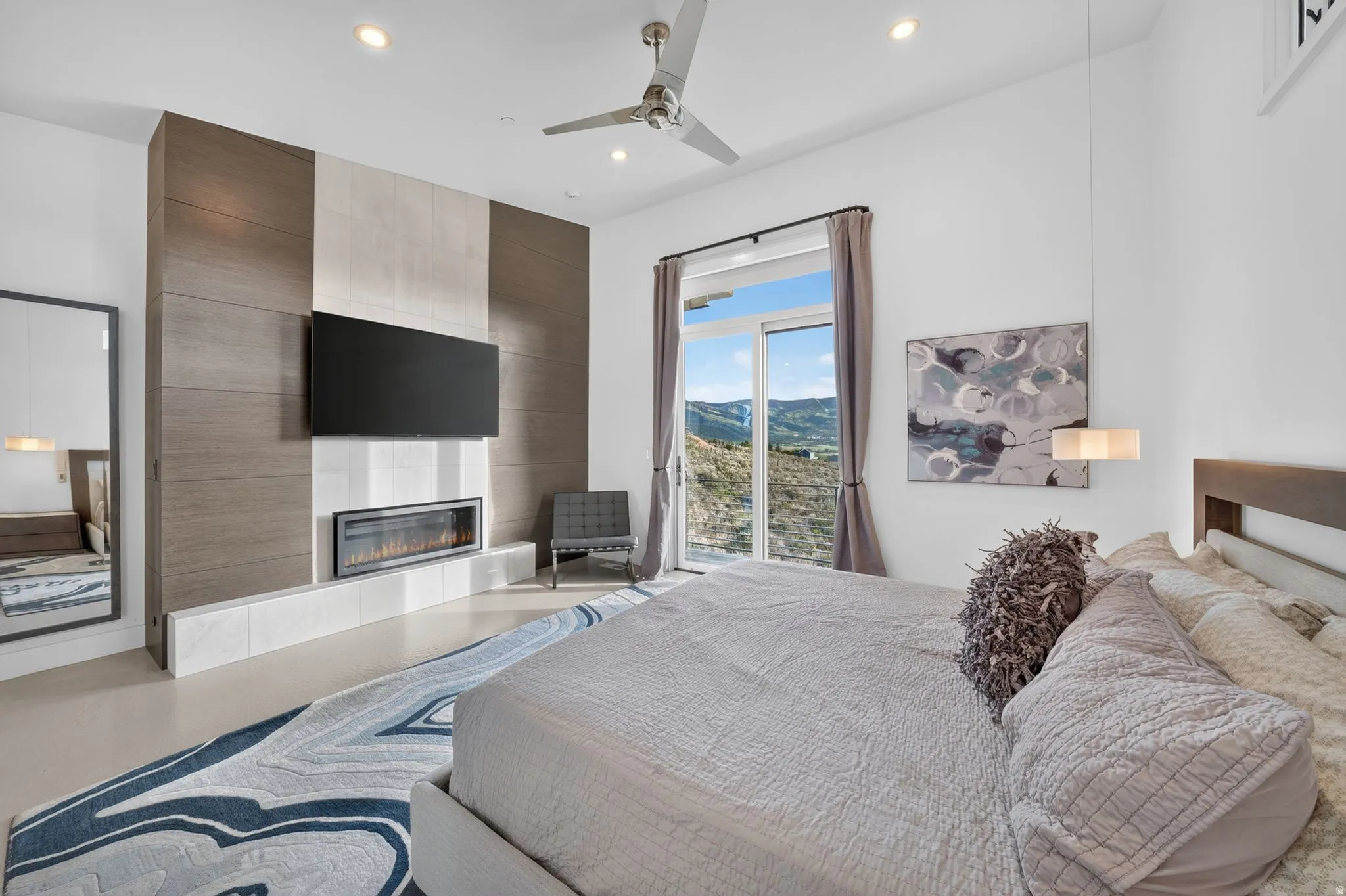 Feature wall with integrated linear fireplace, sliding glass door, recessed lighting, and ceiling fan