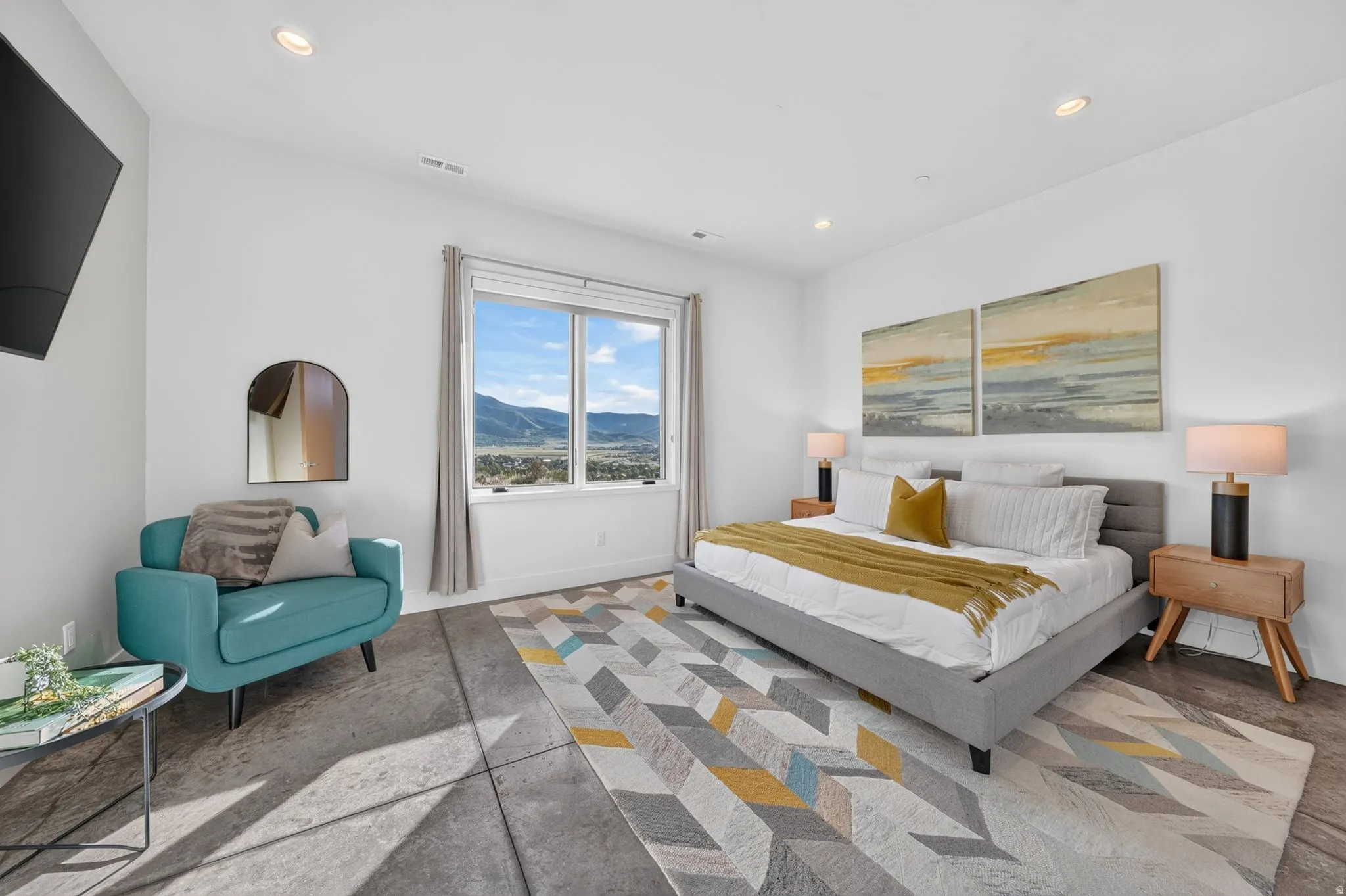 Expansive window with mountain scenery, recessed lighting, and concrete-finish flooring