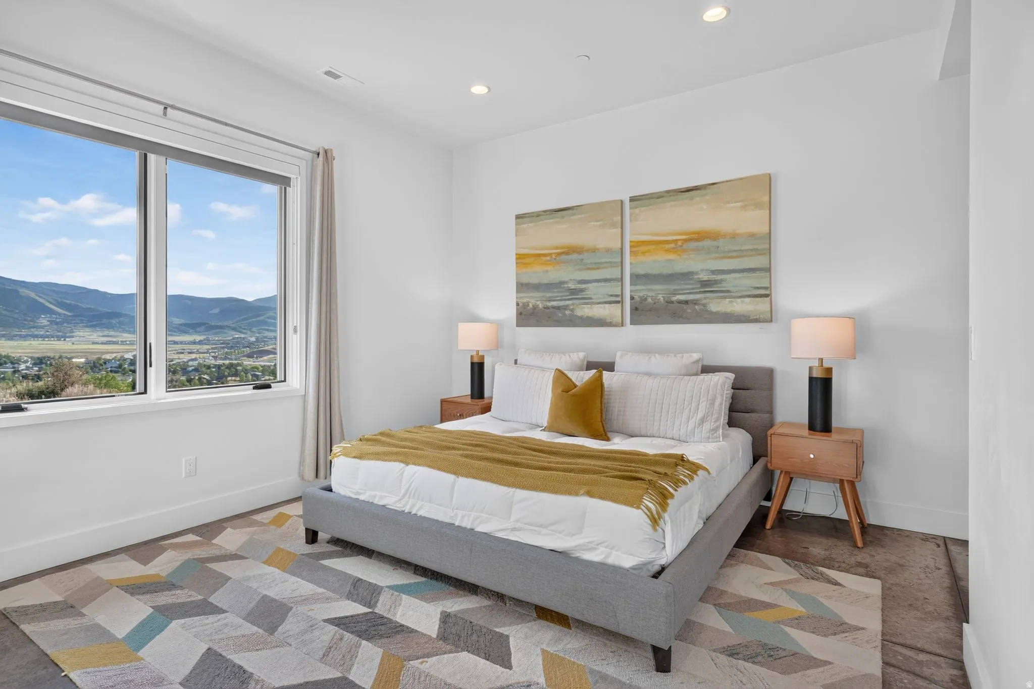 Recessed ceiling lighting, large window with expansive outdoor scenery, white walls, and dark flooring