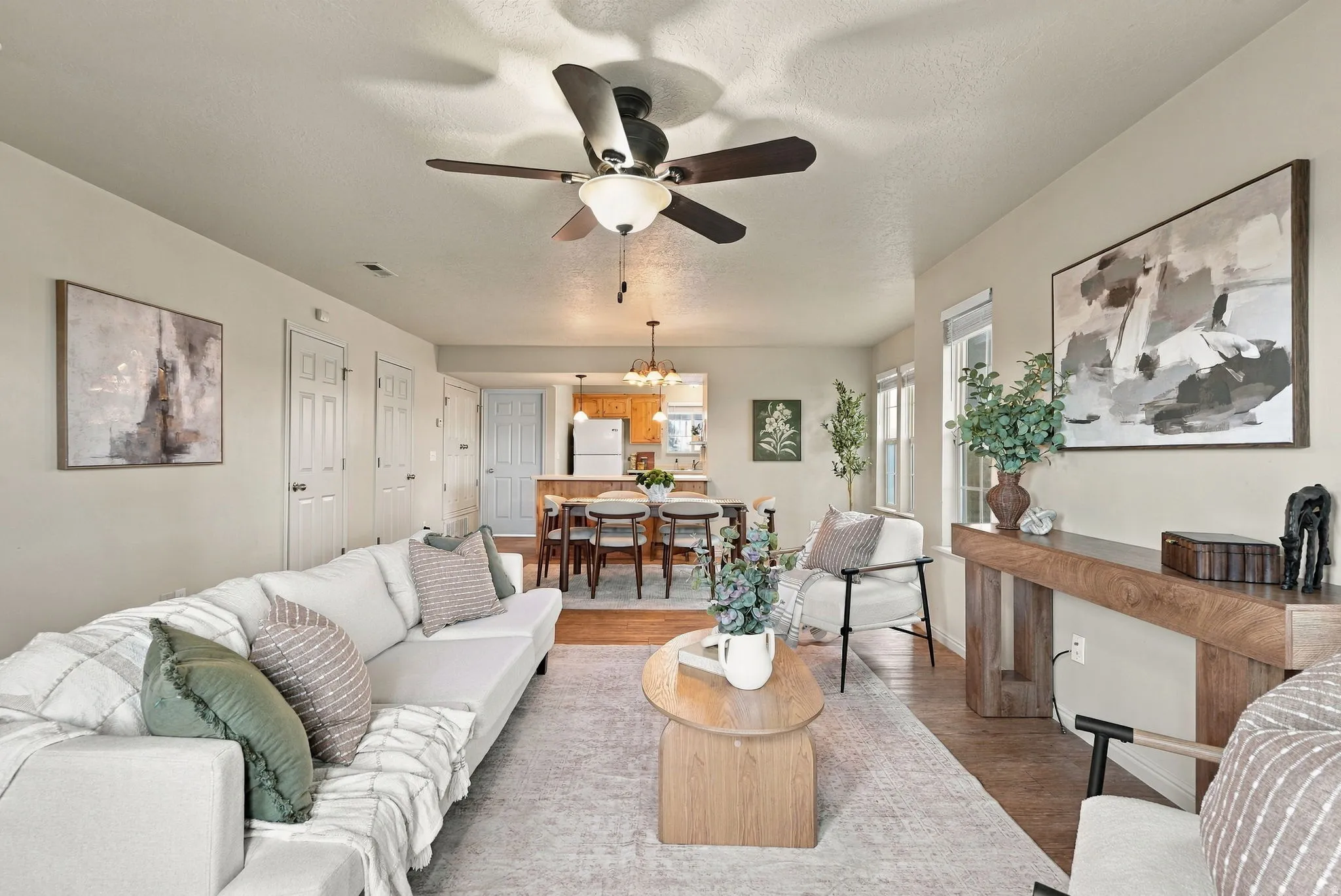 Living area with a ceiling fan, wood-finish flooring, and recessed lighting